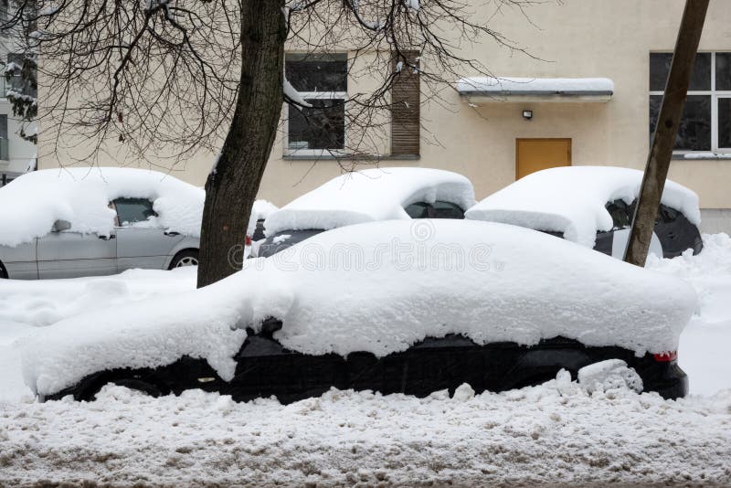 Auto unter dicken Schneedecke nach Sturm. Fahrzeuge unter Eis