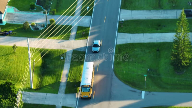 Autobus di scuola gialla classico dell'America che percorre una strada rurale per raccogliere bambini per le lezioni di mattina pr