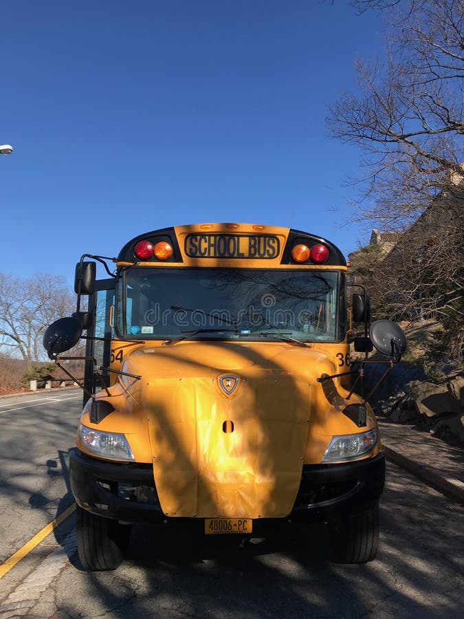 Autobús amarillo de la escuela en la calle en un día soleado contra el cielo azul y el camino imagen de archivo Autobús amarillo de la escuela en la calle en un día soleado contra el cielo azul y el camino imagen de archivo