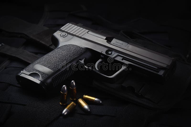 An automatic pistol laid on a tactical vest