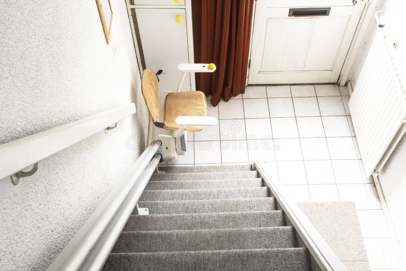 Automatic stair lift on staircase taking elderly people and disabled persons up and down in a house