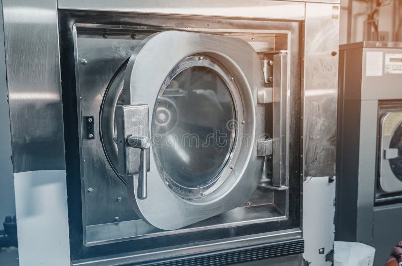 Automatic washing machine in the dry cleaning room. Close-up view of the washing machine door. Automatic loading stock images, royalty-free photos and pictures