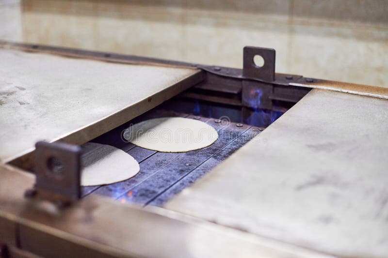 Automatisk rotistmaskin vid gurudwara bangla sahib-tempel automatisk matning av chapati arkivbilder