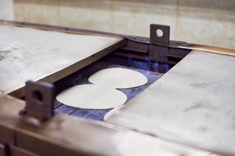 Automatisk rotistmaskin vid gurudwara bangla sahib-tempel automatisk matning av chapati royaltyfri foto
