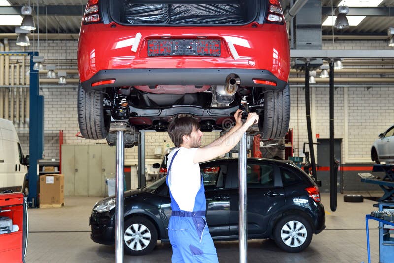 Automechaniker repariert Fahrzeug in einer Werkstatt stockfotos Automechaniker repariert Fahrzeug in einer Werkstatt stockfotos