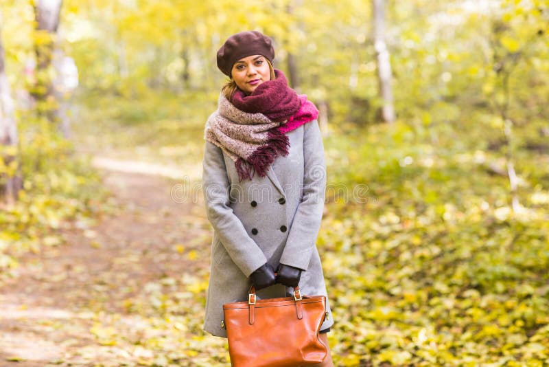 Automne, nature, concept de personnes - belle jeune femme dans un manteau gris et un béret se tenant en parc images libres de droits Automne, nature, concept de personnes - belle jeune femme dans un manteau gris et un béret se tenant en parc images libres de droits