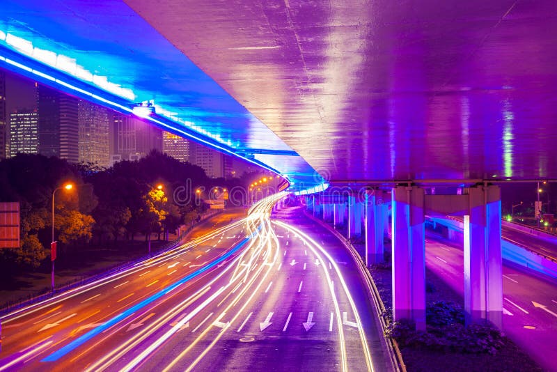 Automobile commovente con l'indicatore luminoso della sfuocatura attraverso la città alla notte immagine stock libera da diritti Automobile commovente con l'indicatore luminoso della sfuocatura attraverso la città alla notte immagine stock libera da diritti