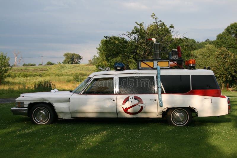 A white Cadillac automobile embellished and designed to look similar to the Ecto-1 vehicle from the movie Ghostbusters. A white Cadillac automobile embellished and designed to look similar to the Ecto-1 vehicle from the movie Ghostbusters.