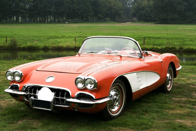 Open top classic corvette car standing outside in a meadow. Open top classic corvette car standing outside in a meadow