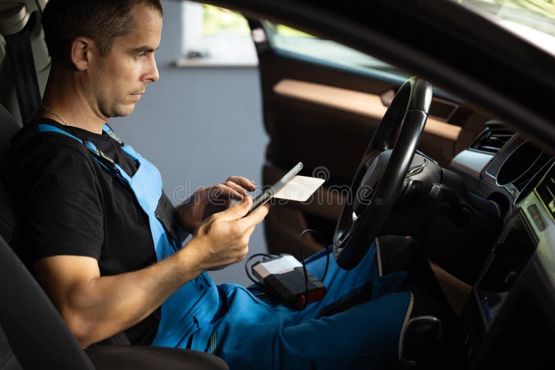 Automotive Mechanic Running Diagnostics Software on Tablet Computer