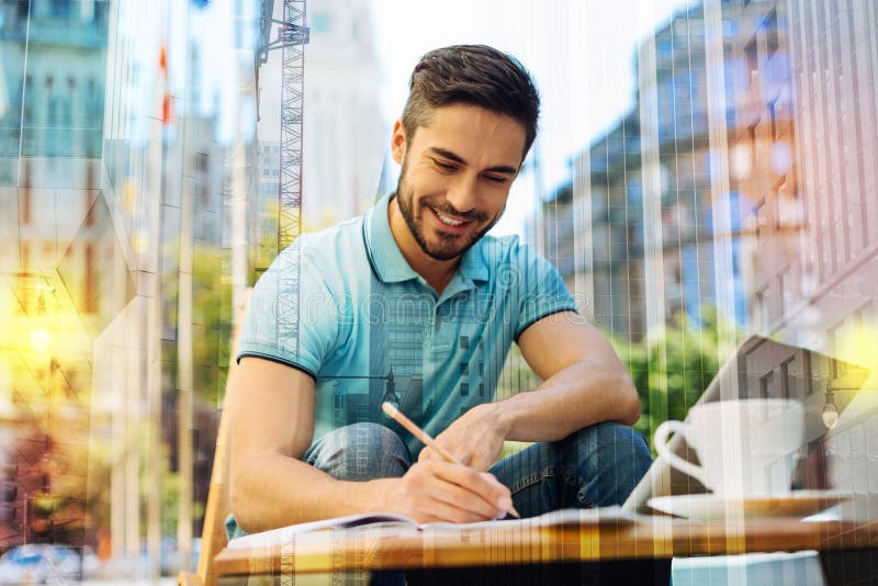Autor joven dotado que acaba su libro y que siente excitado fotos de archivo libres de regalías