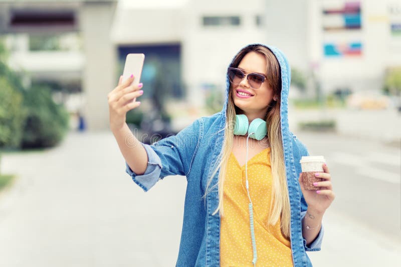 Autorretrato del café de consumición de moda moderno hermoso feliz de la mujer joven en la calle de la ciudad fotografía de archivo libre de regalías Autorretrato del café de consumición de moda moderno hermoso feliz de la mujer joven en la calle de la ciudad fotografía de archivo libre de regalías