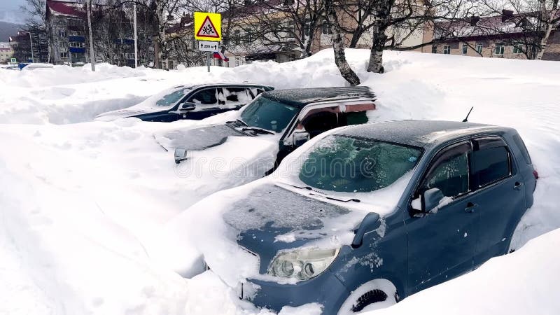 Autos cubiertos de nieve estacionados en estacionamiento en temporada de invierno. auto estacionado cubierto de nieve después de v