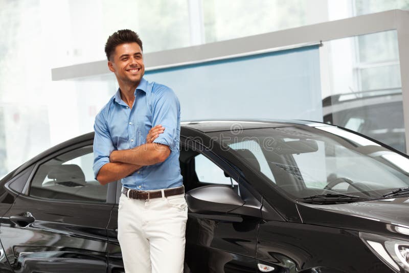 Autotoonzaal Gelukkige Mens dichtbij Auto van Zijn Droom royalty-vrije stock foto Autotoonzaal Gelukkige Mens dichtbij Auto van Zijn Droom royalty-vrije stock foto