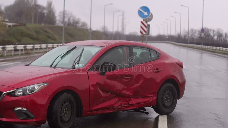 Autounfall auf der Straße während des Regens Rot beschädigter Wagen auf leerer Straße