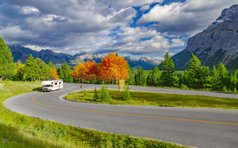 RV Motorhome Recreational Vehicle In Autumn Fall Vacation Road Trip With Colored Leaves. RV Motorhome Recreational Vehicle In Autumn Fall Vacation Road Trip With Colored Leaves