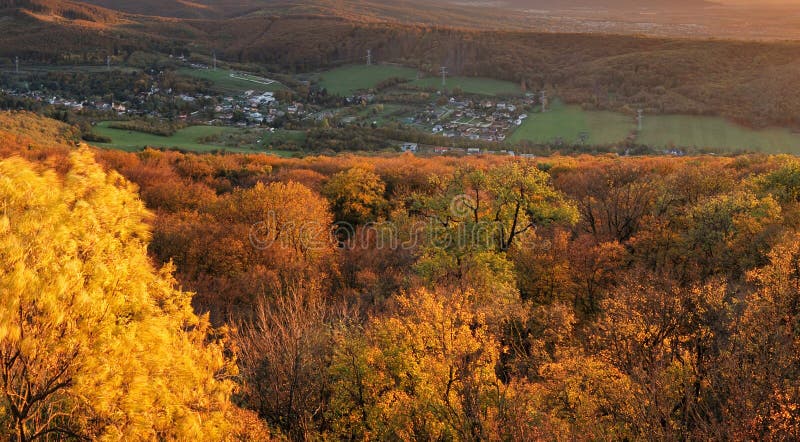 Podzimní barevný západ slunce s vesnicí a lesem, Slovensko - hrad Pajštún