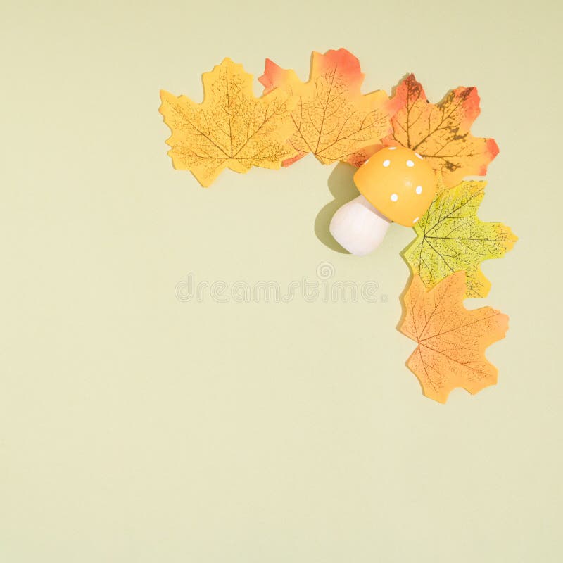 Autumn composition. Frame made of autumn leaves and mashroom on pastel green background. Flat lay, top view, copy space