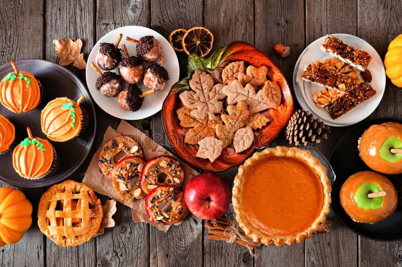 Autumn desserts table scene with a variety of sweet fall treats over  dark wood