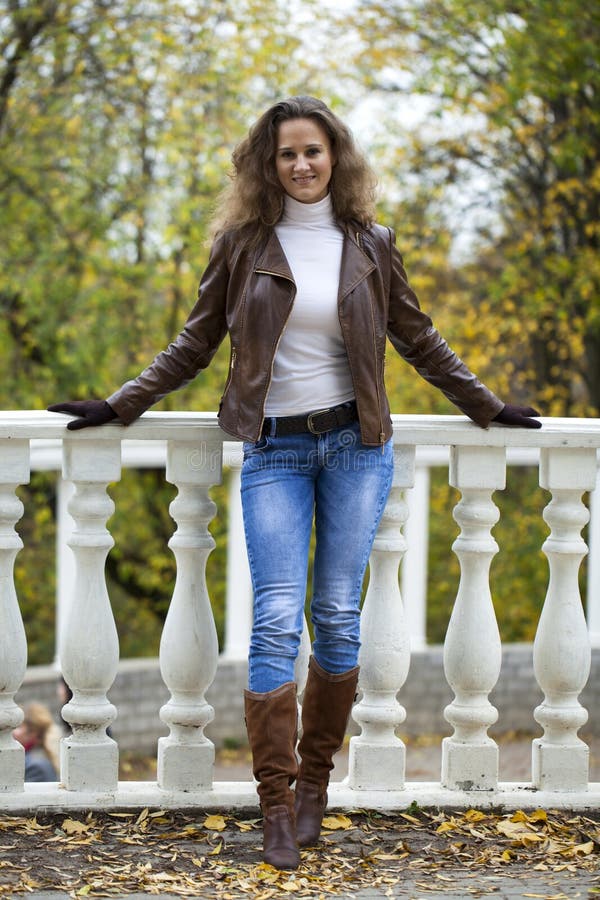 Autumn fashion image of young woman walking in the park