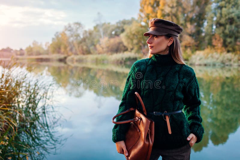Autumn fashion. Young woman wearing stylish outfit and holding handbag outdoors. Clothing and accessories royalty free stock image Autumn fashion. Young woman wearing stylish outfit and holding handbag outdoors. Clothing and accessories royalty free stock image