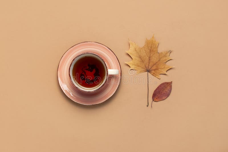 Autumn Flat lay composition. Cup of tea, autumn dry bright leaves, roses flowers, orange circle, cones, decorative pomegranate