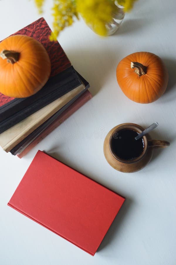 Autumn still life with books, pumpkins, cup