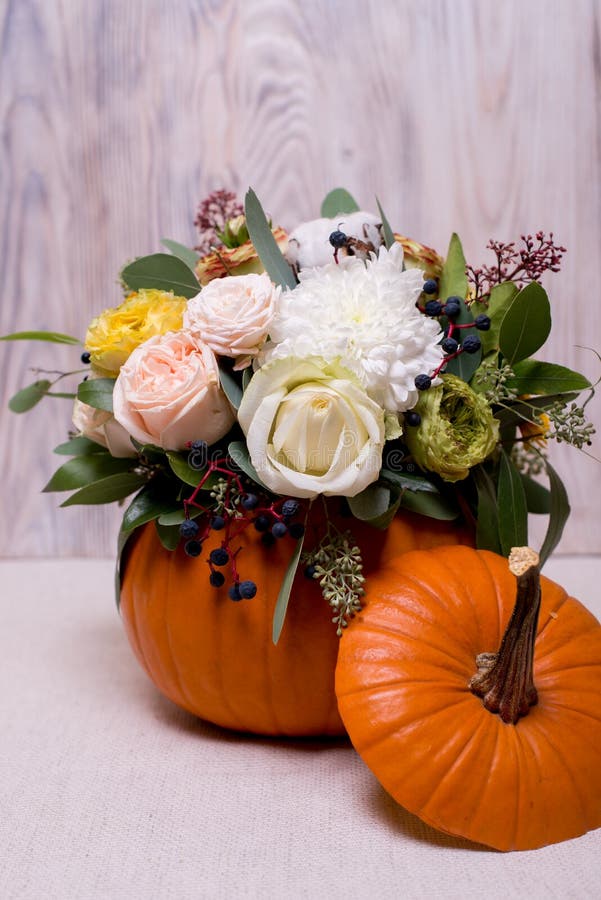 Autumn Floral Bouquet In A Pumpkin Vase A Light autumn floral bouquet pumpkin vase light background mixture flowers pionic rose eucalyptus chrysanthemum