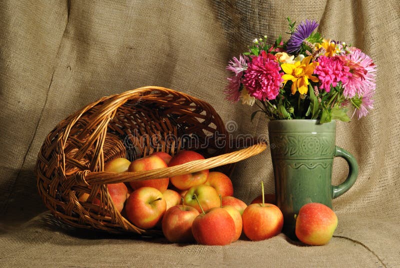 The autumn flowers and red apples