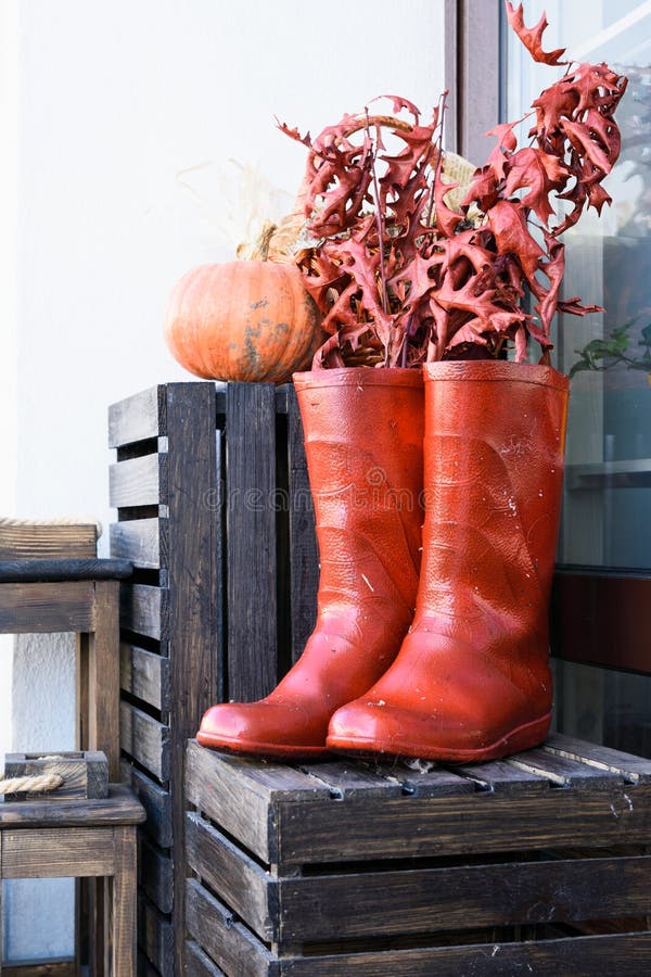 a pair of red boots on a wooden box on the background of a wall and pumpkins stock photography a pair of red boots on a wooden box on the background of a wall and pumpkins stock photography