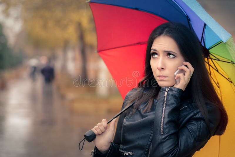 Autumn Girl Holding ein Regenbogen-Regenschirm und Smartphone stockfotos Autumn Girl Holding ein Regenbogen-Regenschirm und Smartphone stockfotos