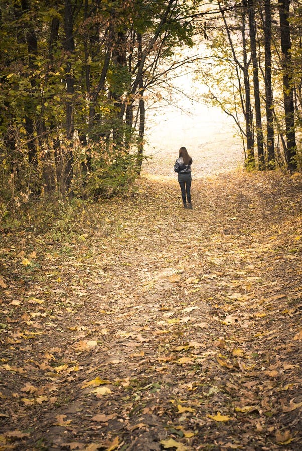 Autumn: Girl on the road in the park, forest.