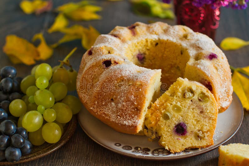 Autumn grapes fruit cake in rustic decor. Homemade bundtcake with autumn grapes on a table with fall decoration stock photos Autumn grapes fruit cake in rustic decor. Homemade bundtcake with autumn grapes on a table with fall decoration stock photos