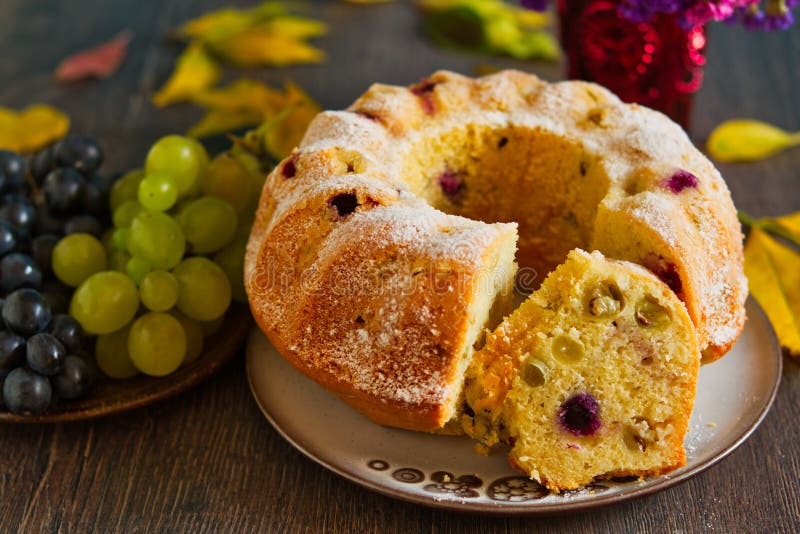 Autumn grapes fruit cake in rustic decor. Homemade bundtcake with autumn grapes on a table with fall decoration royalty free stock images Autumn grapes fruit cake in rustic decor. Homemade bundtcake with autumn grapes on a table with fall decoration royalty free stock images
