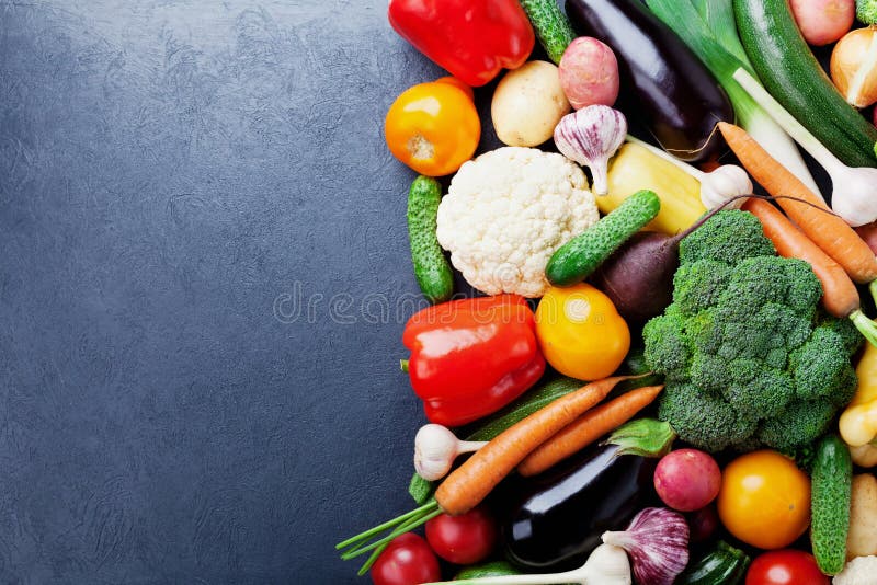 Autumn harvest farm vegetables and root crops on black kitchen table top view with copy space for text. Healthy and organic backgr