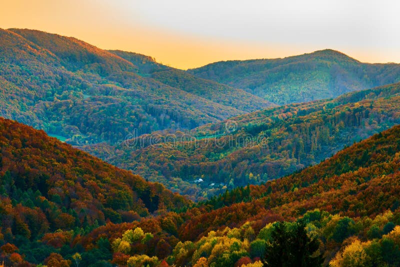 Autumn landscape at dusk. With a lonely house in a mountain valley.