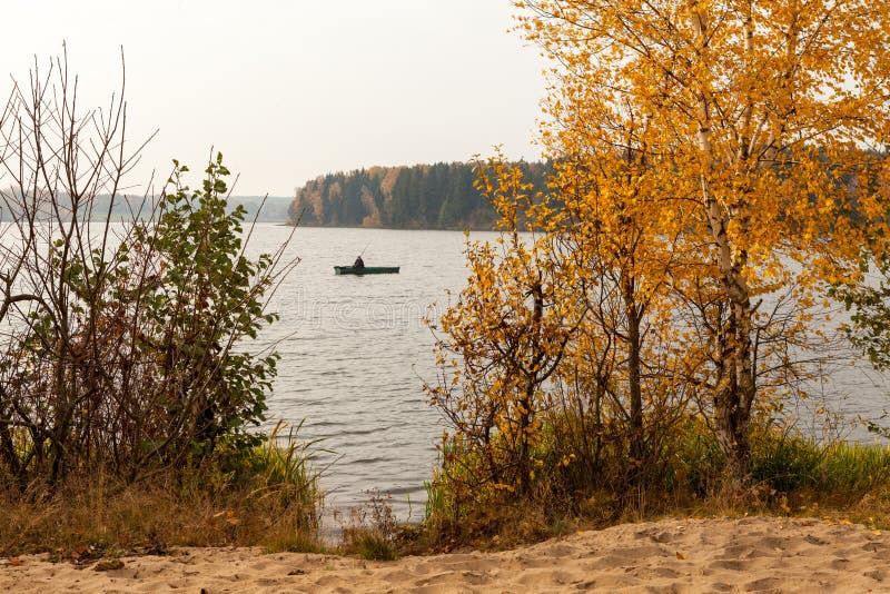 Autumn landscape with fisherman