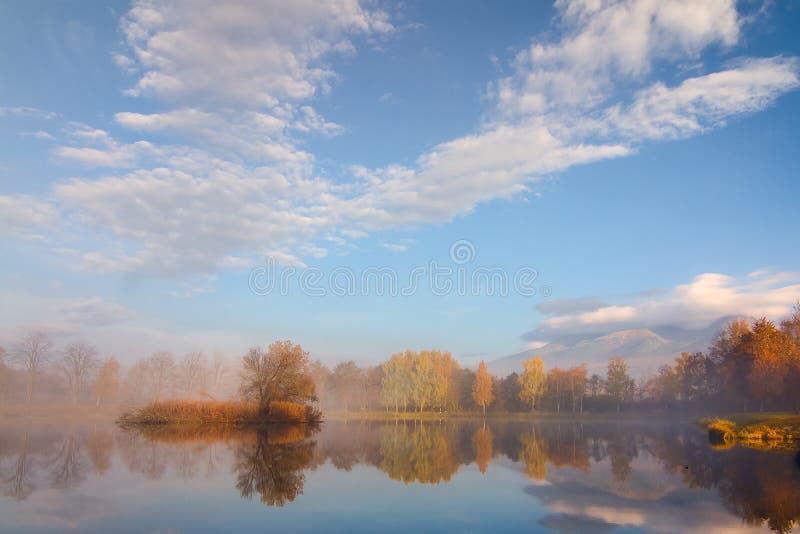 Autumn landscape and foggy lake