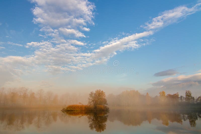 Autumn landscape and foggy lake