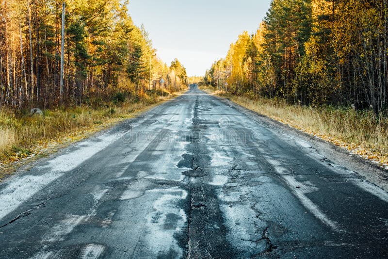 Autumn landscape with road by damaged asphalt, trees and sky stock photos Autumn landscape with road by damaged asphalt, trees and sky stock photos