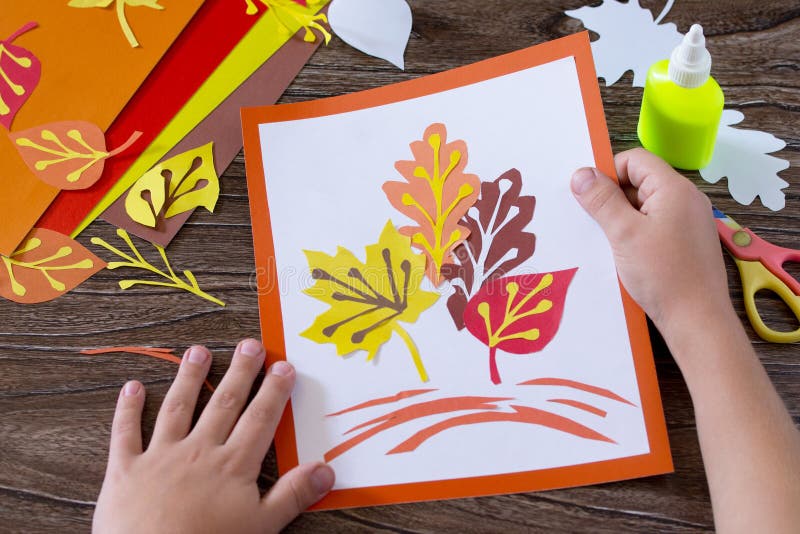 Autumn colored paper leaves on the wooden background. The child cuts out paper  leaves. Sheets of paper crafts for kids. Children Stock Photo - Alamy