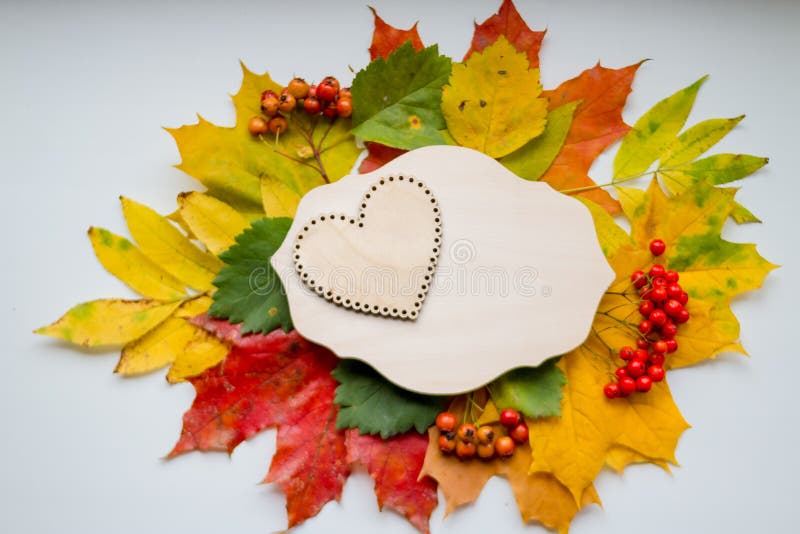 Autumn leaves with wooden heart. Symbol for loving autumn season. Autumn mood. Seasonal sales. Autumn holiday.wedding