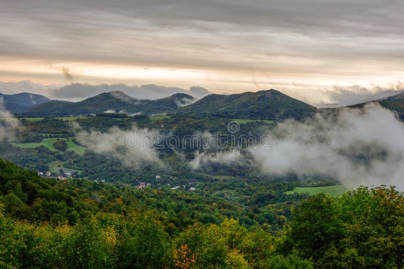 Fog rolling into the valley, autumn  landscape with forest.