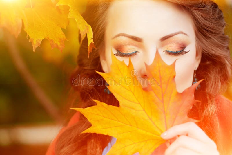 Autumn model, bright make up. woman on background fall landscape