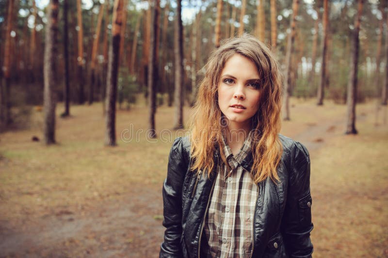 Autumn outdoor portrait of young beautiful woman with natural makeup in leather jacket and plaid shirt stock image Autumn outdoor portrait of young beautiful woman with natural makeup in leather jacket and plaid shirt stock image