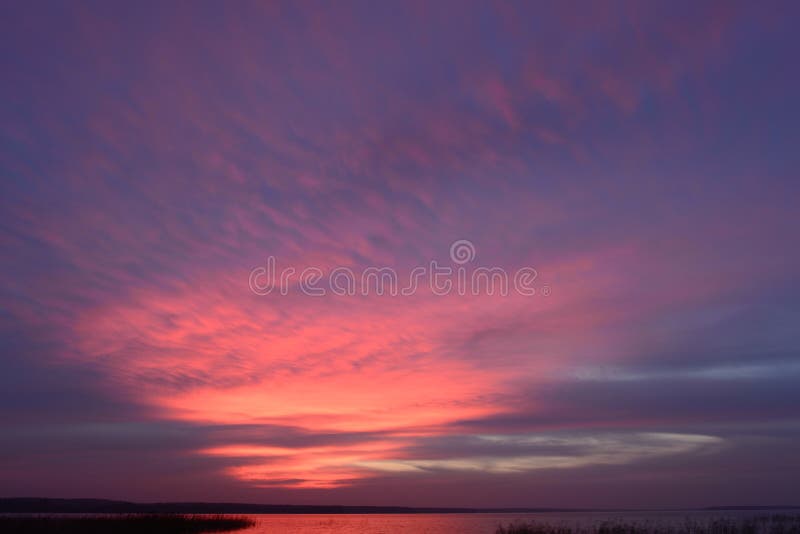 Autumn picturesque the twilight sky in the bright glowing colors of the sunset above the water surface of the lake royalty free stock photo Autumn picturesque the twilight sky in the bright glowing colors of the sunset above the water surface of the lake royalty free stock photo