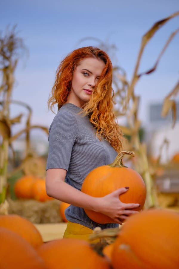 Autumn portrait of a beautiful woman with pumpkins