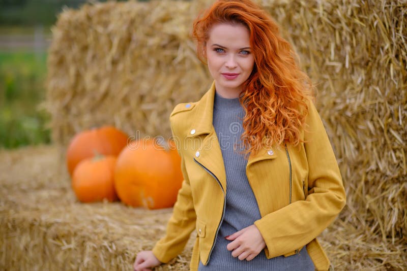 Autumn portrait of a beautiful woman with pumpkins