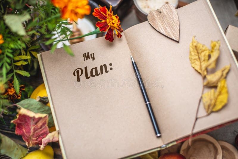 Autumn set of yellow leaves and flowers. Notebook with open pages on the table. Space for text. Top view. Concept my plan