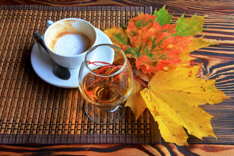 Autumn still life with cup of coffee, brandy and leaves